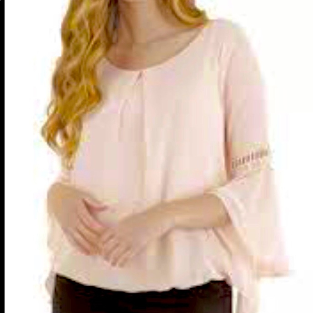 A Buyer womans small pink top with flared sleeves.